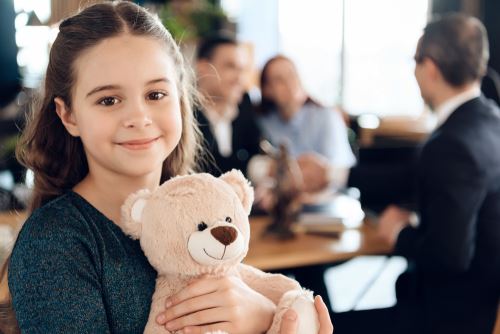 Adopted girl holding a teddy bear